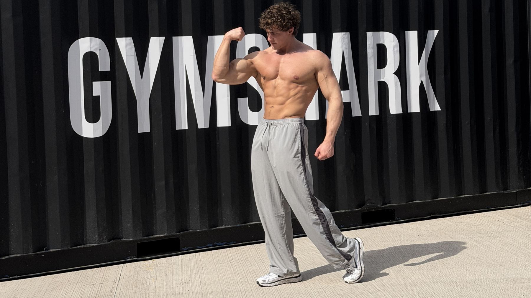 Kyle Raison posing in front of a Gymshark shipping container